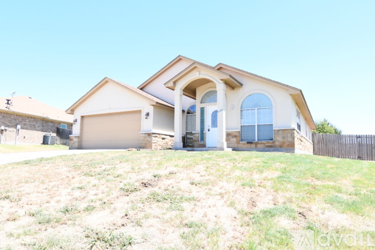 A house with a white garage door and a stone wall.
