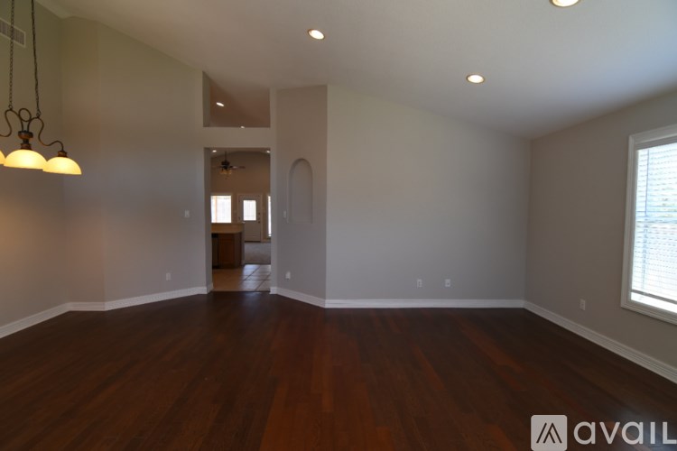 A room with wooden floors and a window on the right side.
