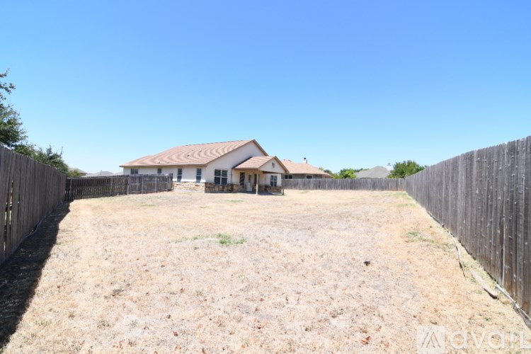A house with a fenced yard in front of it.