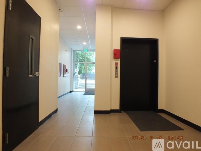 A hallway with two doors and a window in the background.