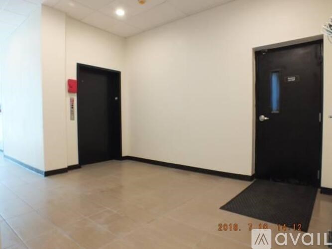 A hallway with two doors, one of which is black and has a glass panel.