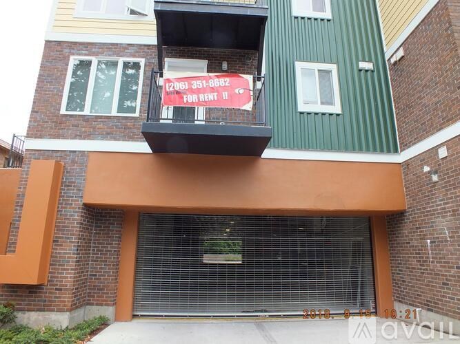 A building with a balcony has a sign that says "FOR RENT".