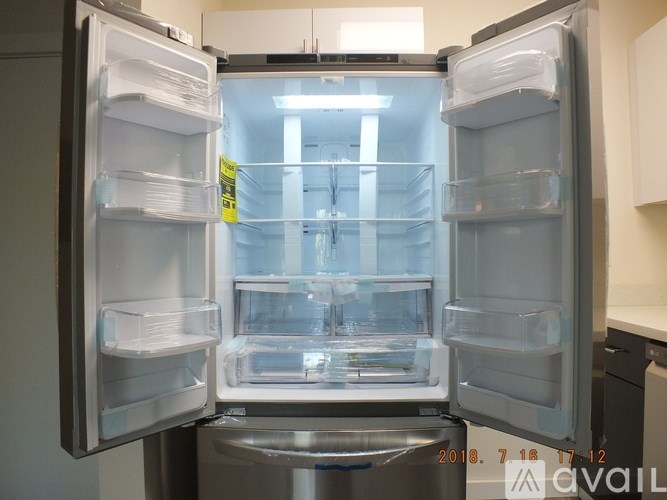 A refrigerator with its door open showing empty shelves.