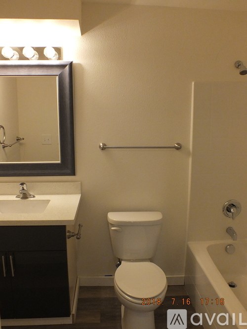 A white toilet in a bathroom with a mirror above it.