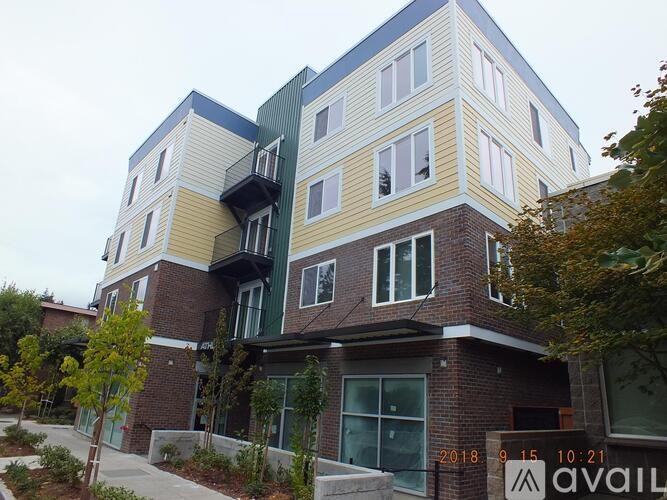 A modern multi-story building with balconies and a mix of brick and panel exterior walls.