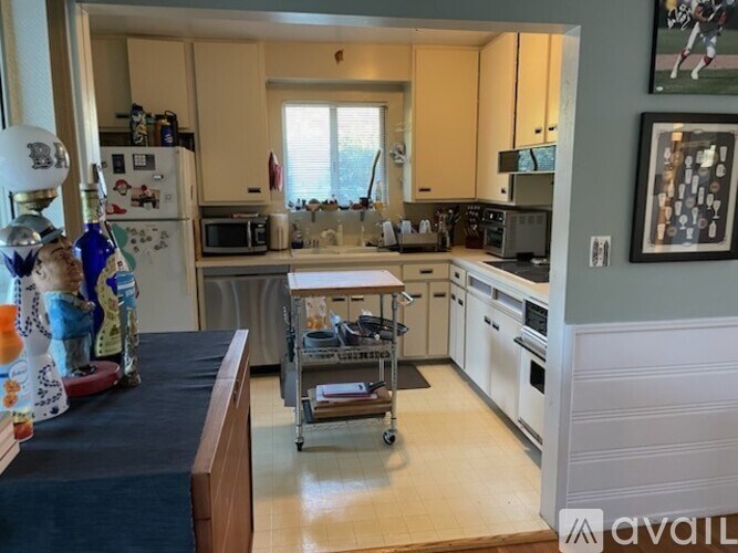 A kitchen with a refrigerator, microwave, oven, and sink.