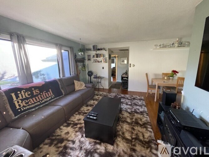 A living room with a brown couch and a rug.