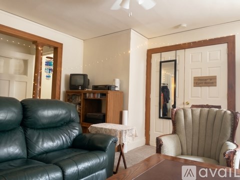 A living room with a Christmas tree and a brown couch.