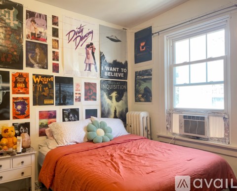 A bedroom with a bed, a wardrobe, a dresser and a wall hanging.