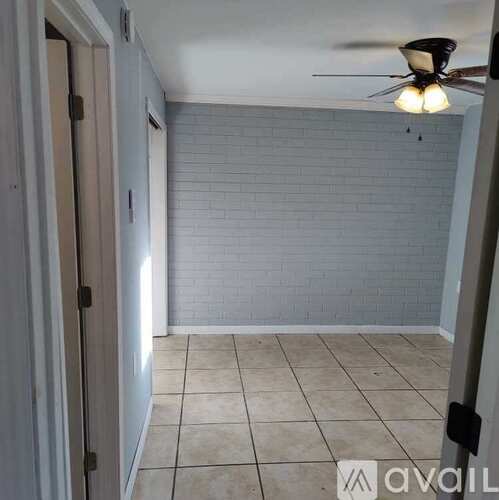 A room with a ceiling fan and tiled floor.