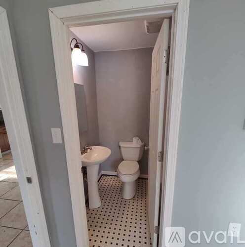 A small bathroom with a toilet, sink, and a pink wall.