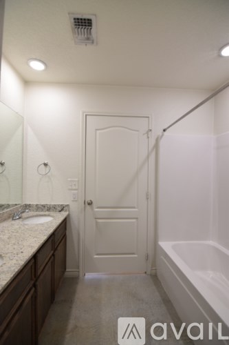 A bathroom with a sink, mirror, and bathtub.