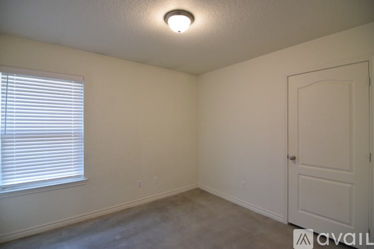 A room with a door, window, and a light on the ceiling.