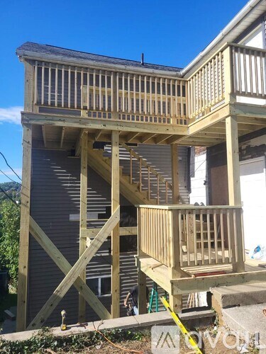 A wooden deck is being built on the side of a house.