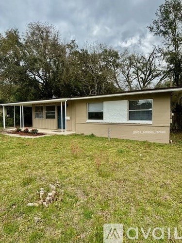 A beige mobile home with a porch and a yard.