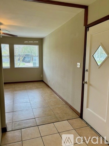 A hallway with tiled flooring and a white door.