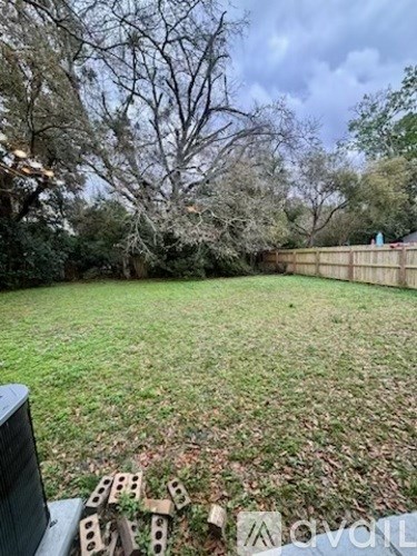 A backyard with a wooden fence and a lawn.
