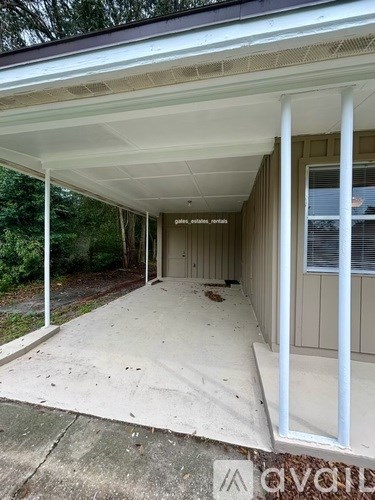 A covered porch with a white ceiling and a door.