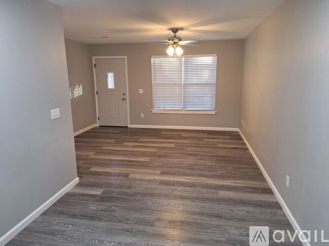 A room with wooden flooring and a ceiling fan.