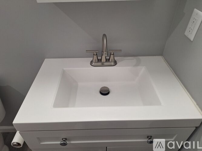 A white sink with a silver faucet in a bathroom.