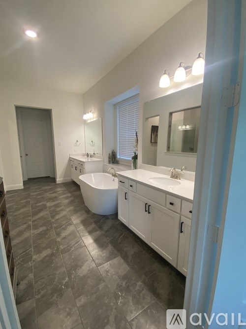A bathroom with a tub, sink, and mirror.