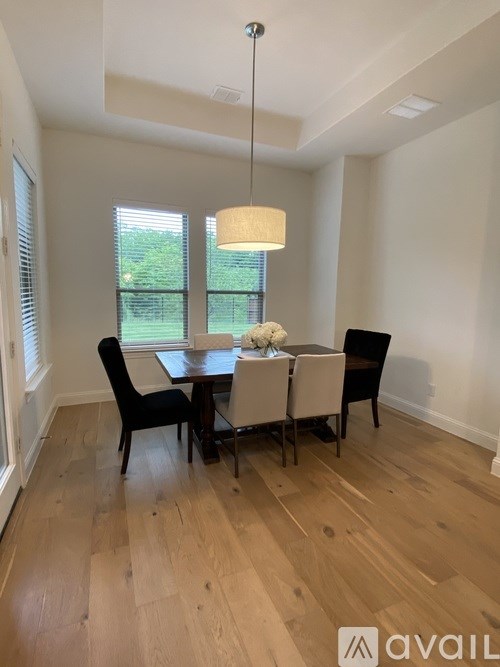 A dining room with a table and chairs.