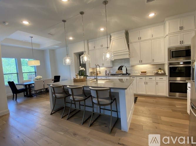 A modern kitchen with white cabinets and a center island.