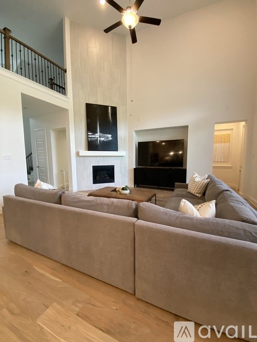 A living room with a grey couch and a fireplace.