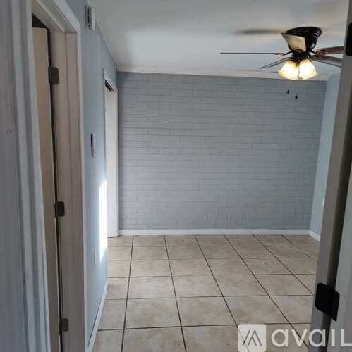 A room with a ceiling fan and tiled floor.