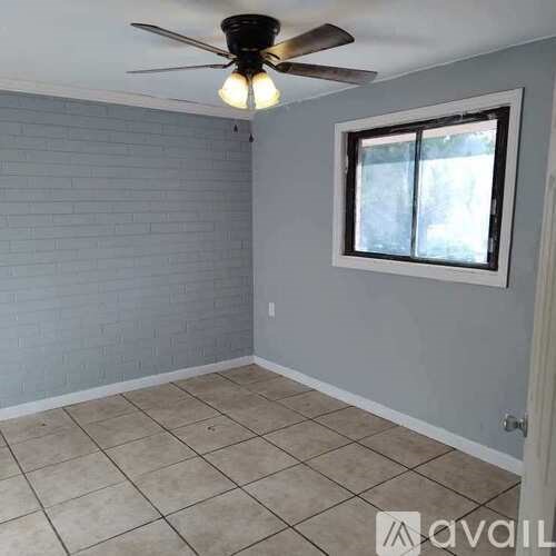 A room with a ceiling fan and a window.