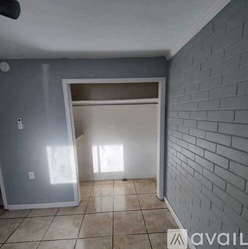 A room with a brick wall and a sliding door.