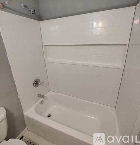 A white bathroom with a toilet, tub, and shower.