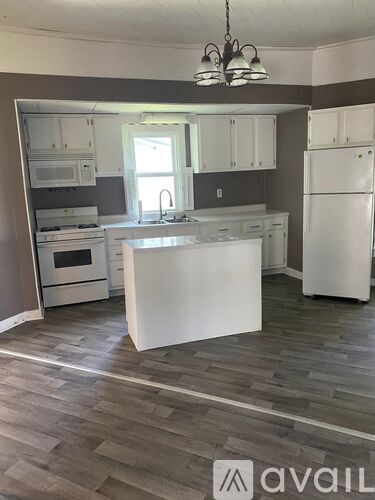 A kitchen with white appliances and cabinets.