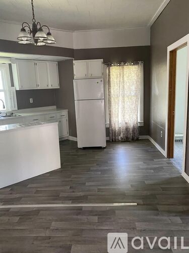 A kitchen with a white fridge and cabinets.