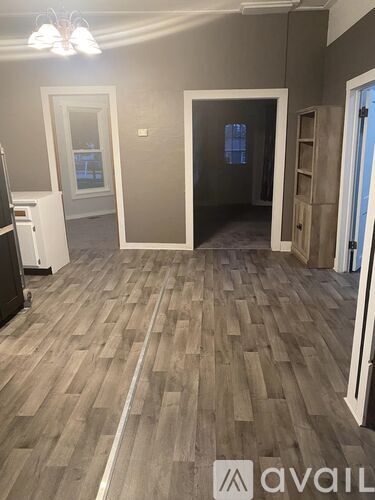 A room with wooden flooring and a white door.