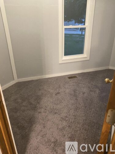 A room with a carpeted floor and a window.