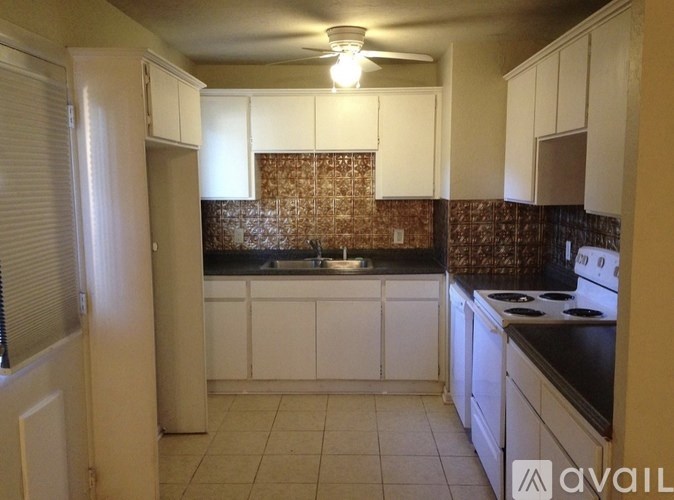 A kitchen with white cabinets and a brick backsplash.