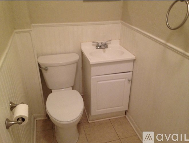 A white toilet and sink in a small bathroom.