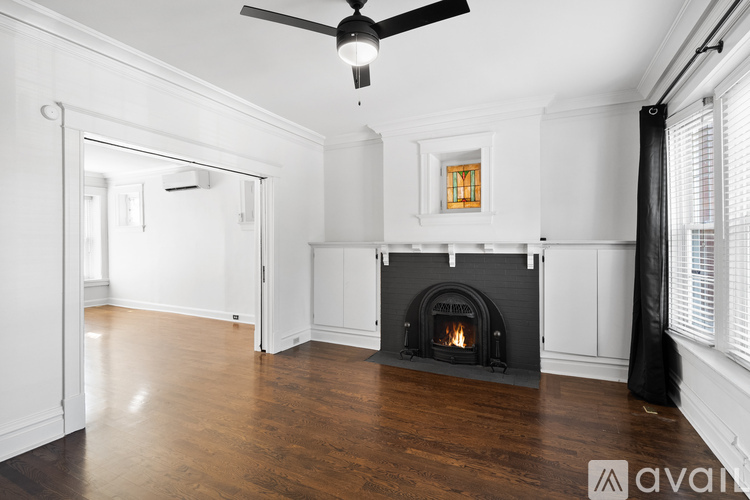 A living room with a fireplace and a ceiling fan.