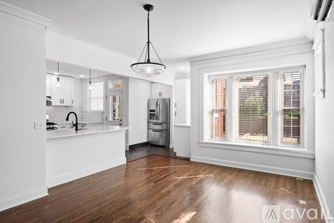 A kitchen with white cabinets and a wooden floor.