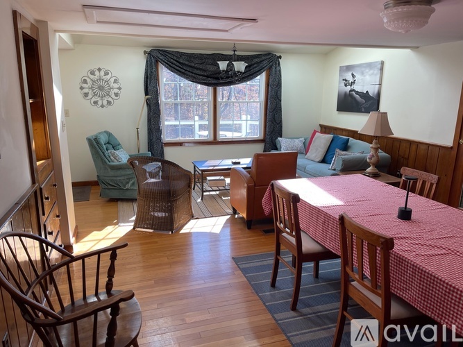 A living room with a sofa, chairs, and a table.