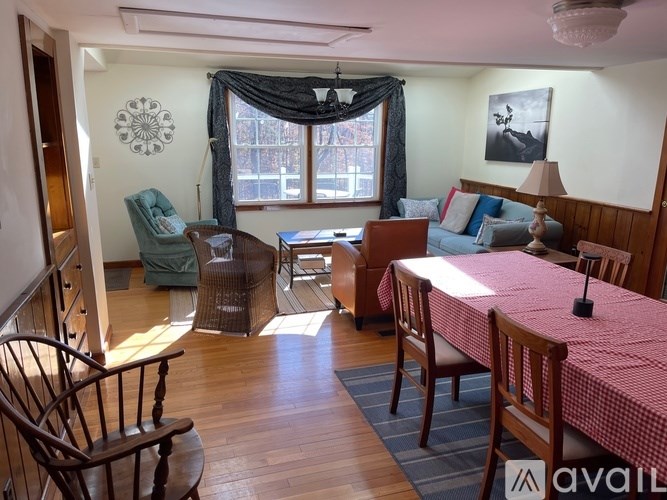 A living room with a sofa, chairs, and a table.