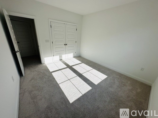 A room with a carpet and a white door.