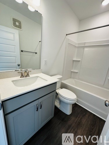 A bathroom with a toilet, sink, and bathtub.