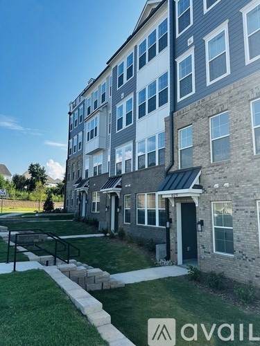 A building with a grassy area in front and a walkway leading to the entrance.