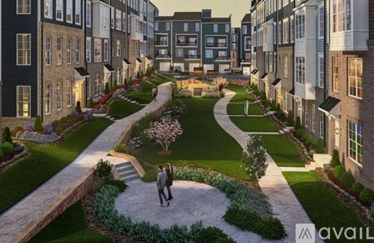 A couple walking through a beautifully landscaped courtyard surrounded by buildings.