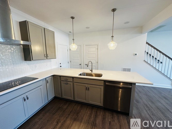 A modern kitchen with a stainless steel dishwasher and a white countertop.