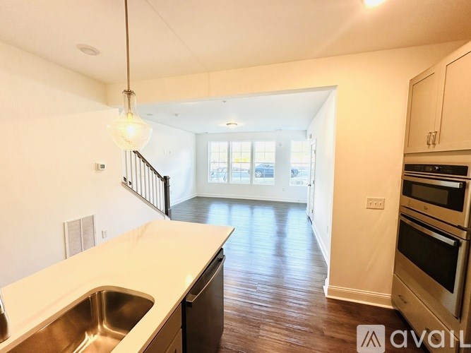 A kitchen with a sink and wooden floors.