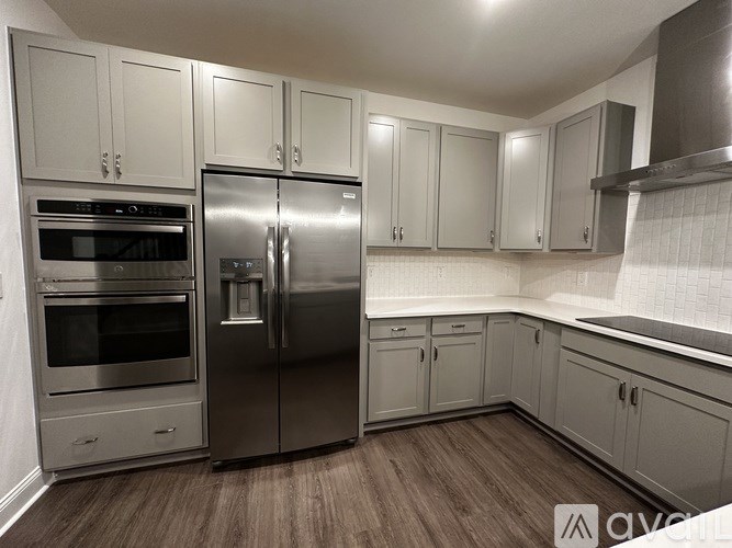 A kitchen with a stainless steel refrigerator and oven.