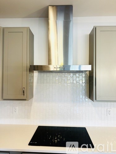 A kitchen with a stove top oven and a range hood.